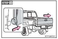 Slide the tailgate a little to the right to unhook the left side.