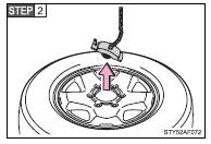 After the tire is lowered completely to the ground, remove the holding bracket.