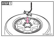 Lay down the tire with the outer side facing up, and install the holding bracket.